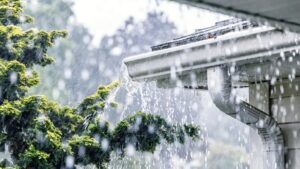 Rainwater flowing through clean gutter system in Antioch CA during winter storm.